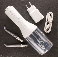 One irrigator, two nozzles and a charger on a slate stone, macro, top view.