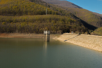 A significant drop in the water level of a mountain reservoir due to drought and high air temperatures.