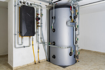 Modern Buffer Tank System Connected to Air-to-Water Heat Pump for Efficient Home Heating and Hot Water Storage in a Residential Setting