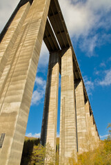 A towering, symmetrical concrete structure of a bridge extends skyward, showcasing architectural beauty in construction.