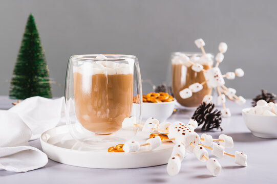 Warm cocoa in cups and snowflakes made of marshmallows and icing on a plate on the table - Powered by Adobe