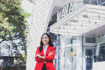 Fototapeta premium A businesswoman standing with her arms crossed on a city street in the morning.