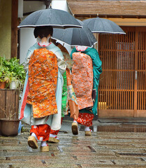 Geishas in a rainy day. Kyoto old town, Japan.