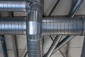 Gros plan sur des gaines inox de ventilation dans une usine industrielle