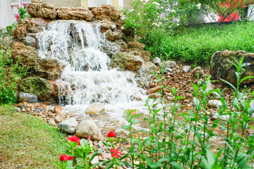 Waterfall is flowing in jungle,Waterfall flowing through rocks in green forest,Stream of water in the forest, Cascading stream in lush forest. Nature background. Rock or stone at waterfall.