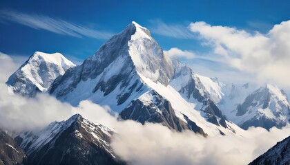 Fototapeta premium Breathtaking view of a majestic snowy mountain peak towering above the clouds, with its pristine white slopes beautifully contrasting against a serene sky and rugged alpine landscape.