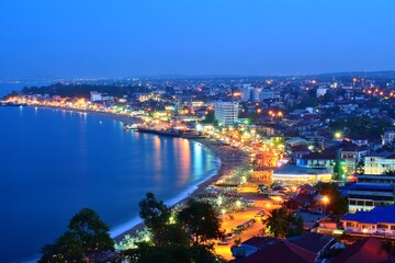 Obraz premium An Aerial View of a Coastal City at Night with Glittering Lights.