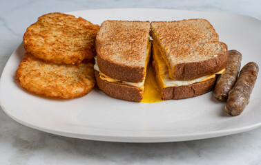 fried egg and cheese sandwich  with hash browns,