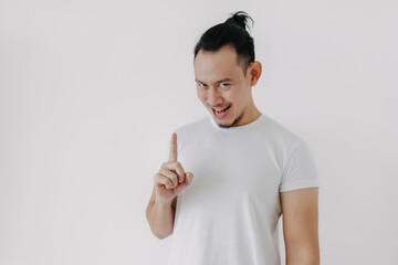 Funny smile of knowing secret tips face Asian man in white t-shirt on white.