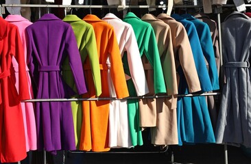 Women's winter coats of different colors on display in the clothing store.
