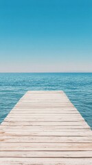 Obraz premium Beautiful wooden pier extending into calm blue ocean under clear sky
