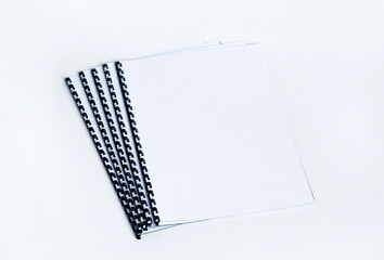 Binded documents with plastic spiral on white background.