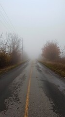 Fototapeta premium Serene Road Shrouded in Fog Disappearing Into the Distance, Evoking a Mystical Atmosphere Perfect for Calm and Reflective Imagery