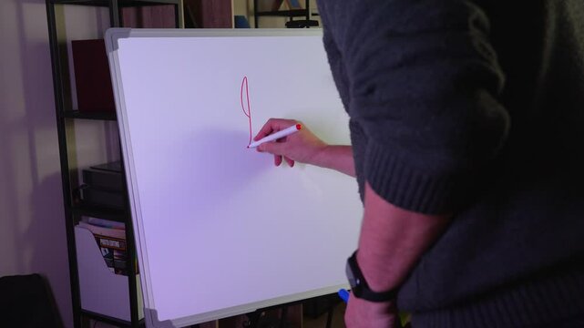 Man writing happy holidays on whiteboard