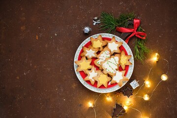Christmas gingerbread cookies in the shape of a Christmas tree and a star with colorful icing and...
