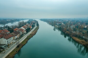 Fototapeta premium Aerial view of a river winding its way through a city, with buildings and infrastructure alongside