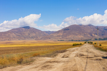 Obraz premium Truck on the gravel road. Lake Sevan area. Mountains in the background. Sevan, Armenia.