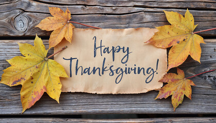 Happy Thanksgiving note with fall leaves with a greeting card on weathered rustic wood