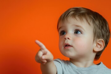 Young boy gestures with finger, attention focused
