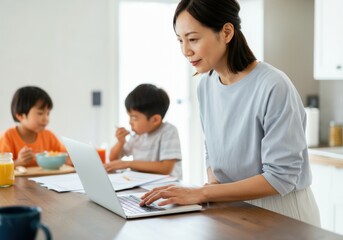 Fototapeta premium Asian mother using laptop computer while her sons eating breakfast in kitchen