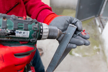 A worker had an accident with his hand while working with a cordless drill to drill a hole in...
