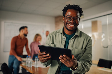 Obraz premium Smiling manager using digital tablet during office meeting