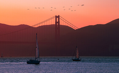 Golden Gate Bridge, San Francisco with sailboats at sunset