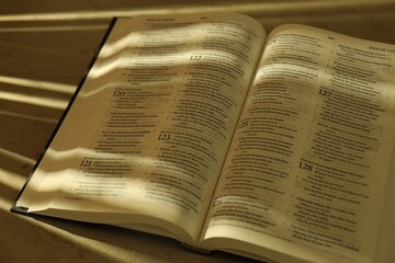 Fototapeta premium Open Holy Bible in English language on table