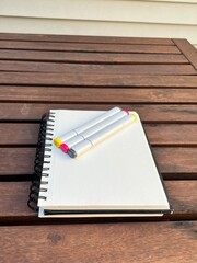 Naklejka premium Blank Sketchbook with Colorful Markers on a Table, Perfect for Creativity, Design, Journaling, or Artistic Projects