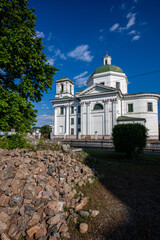 A scenic view of historic churche surrounded by greenery under a vibrant blue sky with scattered clouds. The architecture highlights cultural heritage and peaceful natural surroundings.