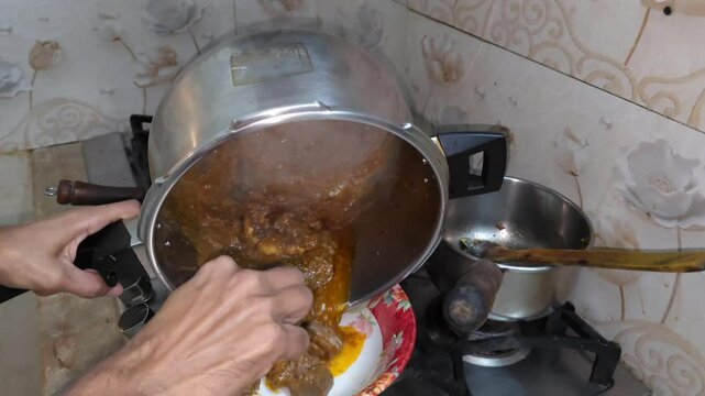Pouring a local Pakistani mutton korma dish in a bowl. 