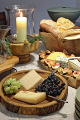 wooden board with cheese and grapes on sophisticated table