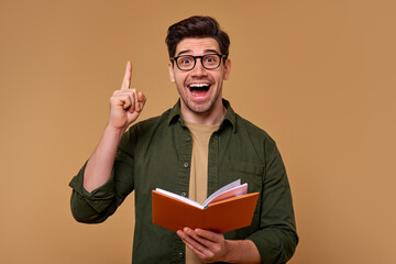 An Enthusiastic Young Man with a Book is Celebrating a Great and Exciting Idea Today