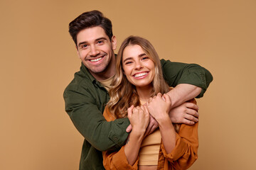 Fototapeta premium A Joyful Young Couple Embracing Each Other Against a Beautifully Warm Background