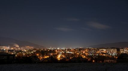 nocna panorama miasta z górawmi w tle