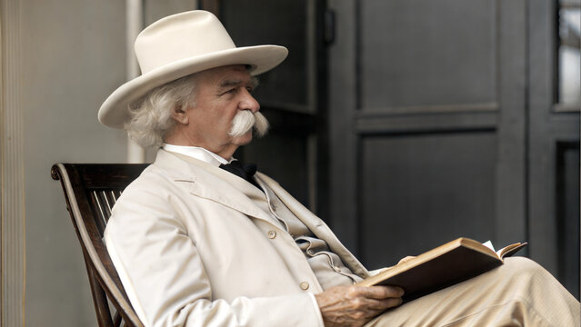 Portrait von Mark Twain in hellem Anzug und Hut, sitzend mit Buch in den H&auml;nden. Profil. Im Stil einer colorierten Fotografie