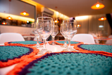 table setting for a dinner, table setting, christmas table setting, crochet sousplat, wine glasses, water glasses, glasses on the table, empty glasses

