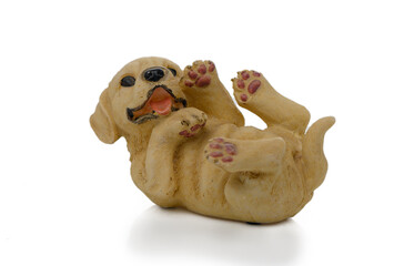 Fototapeta premium Playful ceramic puppy figurine lying on its back with a joyful expression and raised paws