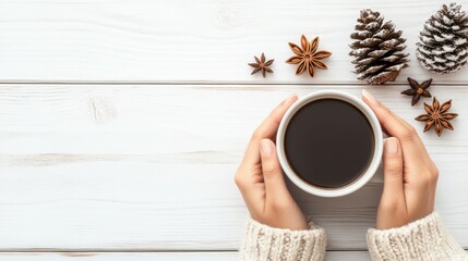 Woman's hands holding mug of coffee with cinnamon, star anise and pine cones over white wooden table. Christmas or New Year holiday background. Flat-lay.
