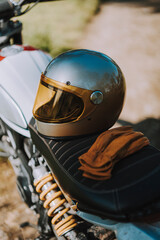 Fototapeta premium Primer plano de motocicleta de campo en bosque con casco en el sillón en camino de tierra
