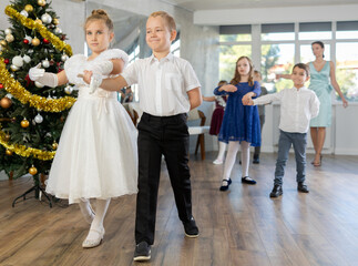 Christmas ball - group of children in festive clothes dances a waltz around the New Year tree