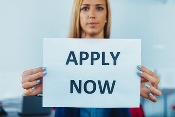 Businesswoman showing apply now sign for job hiring