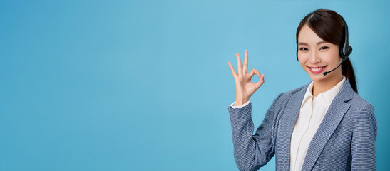OKサインをしている20代のオペレーターのアジア人の女性。（An Asian female operator in her 20s is giving the OK sign.）
