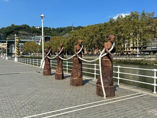 bronze people walking on bridge