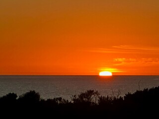 A breathtaking sunset paints the sky in a stunning blend of warm oranges, reds, and yellows as the...