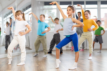 Fototapeta premium Group of boys and girls rehearsing modern dance in studio