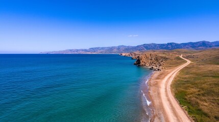 Obraz premium Vintage cars driving along a picturesque coastal highway winding through rugged cliffs that overlook the vast sparkling ocean