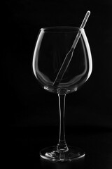 transparent glass goblet with alcohol meter in it on black background