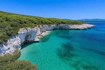 Obraz premium A scenic aerial view of a secluded cove, with crystal-clear water and lush green cliffs surrounding the beach
