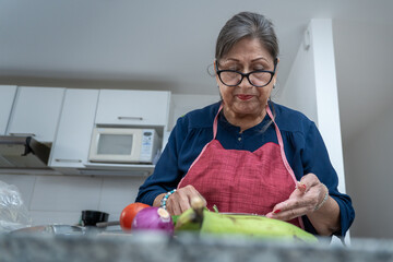Fototapeta premium A woman is cutting up vegetables in a kitchen